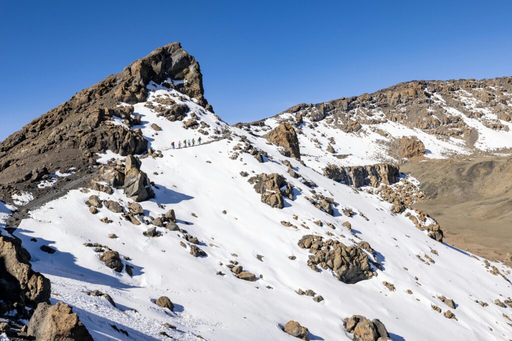 A group of mountaineers scaling the snowy peaks of Mount Kilimanjaro, Tanzania.